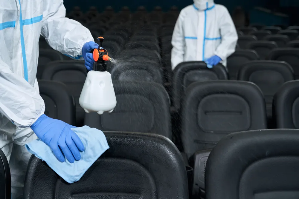 Addetti alle pulizie che puliscono le poltrone di una sala cinematografica